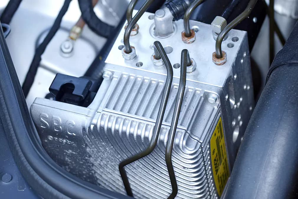 Eingebaute Mercedes SBC Einheit im Fahrzeug mit Bremsleitungen und SBC-Schriftzug am Gehäuse